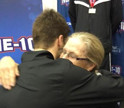 NE-10 champion Connor Mulvey-Hudson embraces his coach, Mary Kay Samko, after winning gold